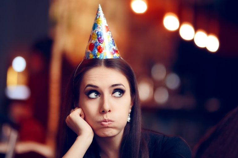 Sad Bored Woman at a Party Having No Fun - Portrait of a funny girl with party hat making faces